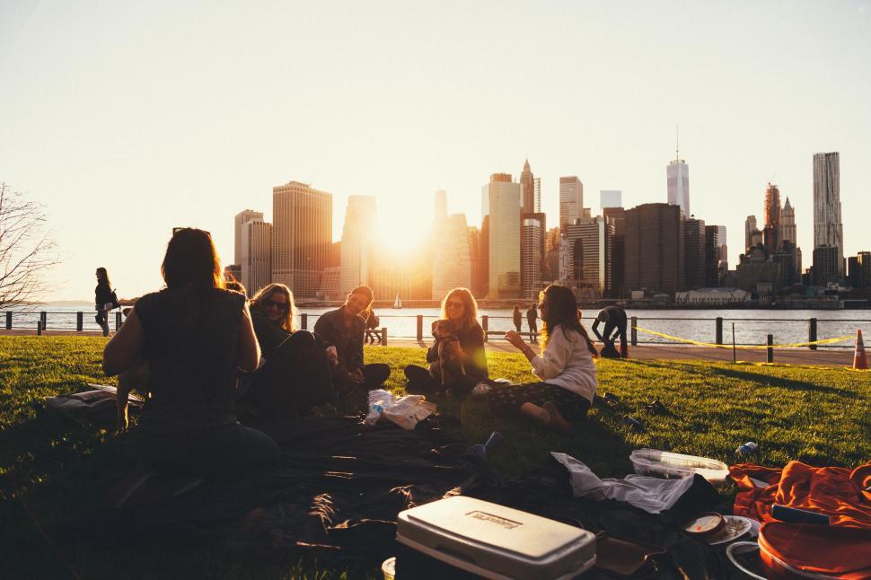 Free Image of Group of People Sitting on Top of Grass Covered Field 