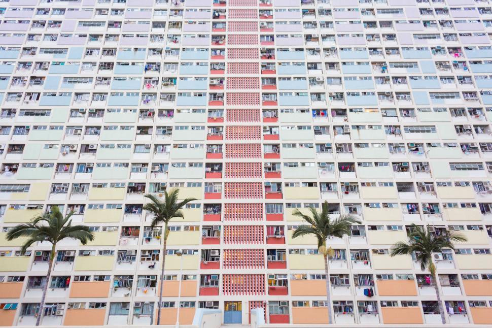 Free Image of Tall Building With Palm Trees in Front 