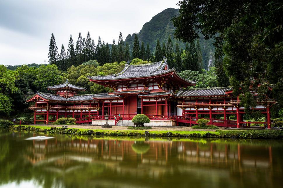Free Image of Large Red Building Next to Body of Water 