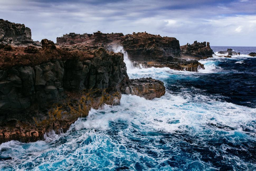 Free Image of Massive Body of Water Alongside Rocky Cliff 