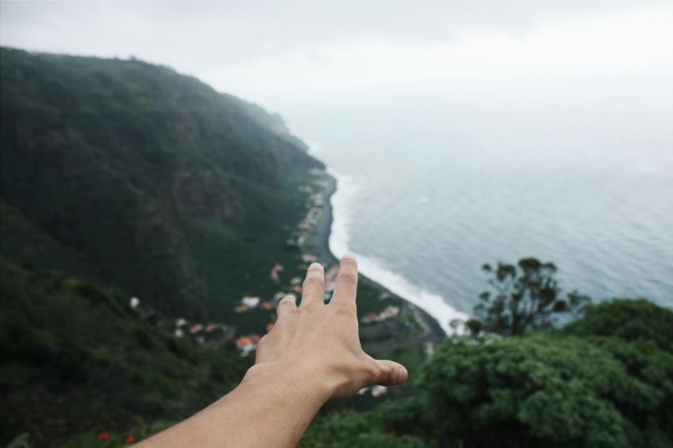 Free Image of Hand Reaching Towards Body of Water 