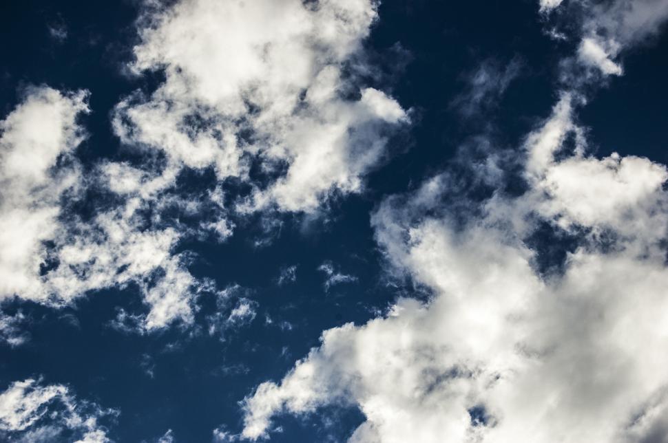 Free Image of Plane Flying Through Cloudy Blue Sky 