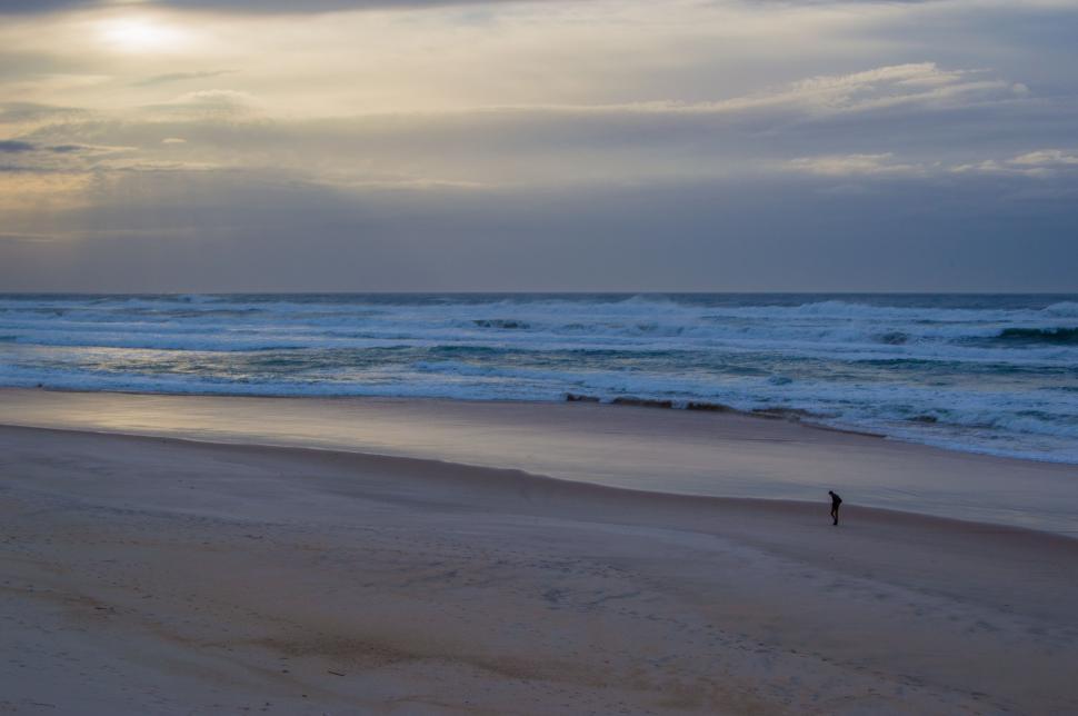 Free Image of Person Walking on Beach Next to Ocean 
