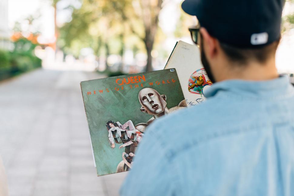 Free Image of Man Reading a Book on the Sidewalk 