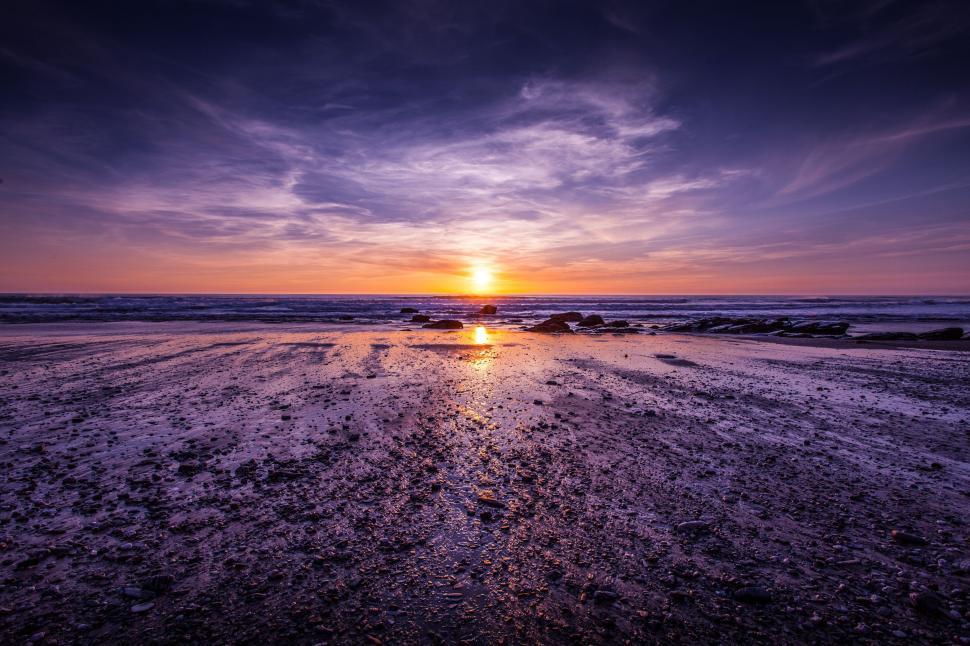Free Image of Sun Setting Over Ocean on Beach 