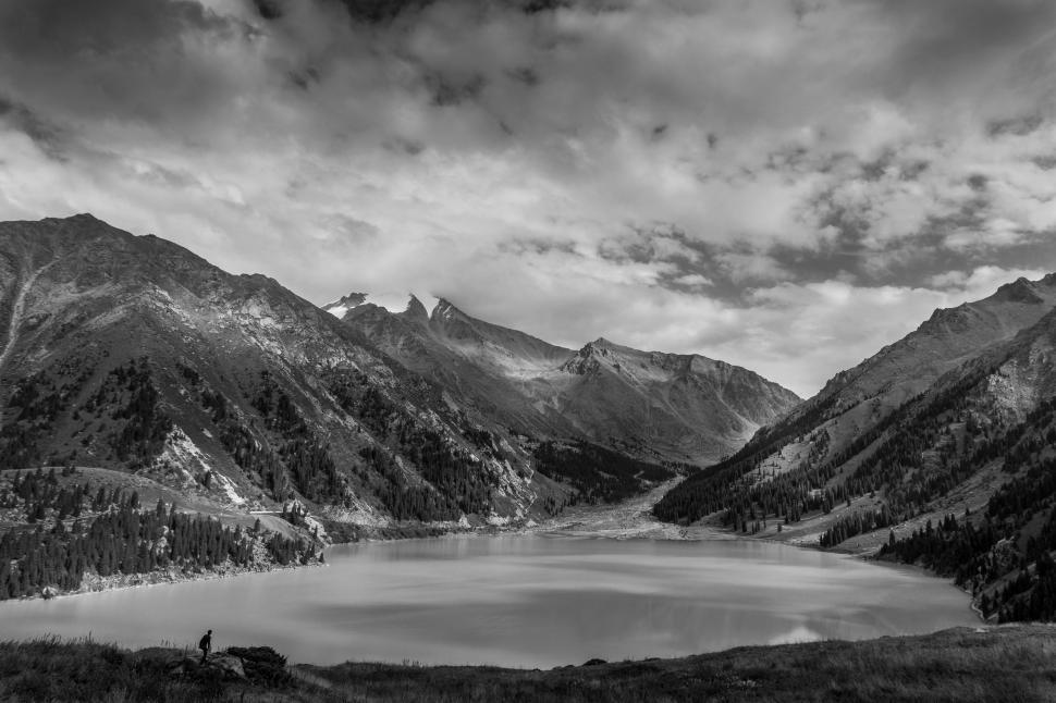 Free Image of Lake Surrounded by Mountains Under Cloudy Sky 