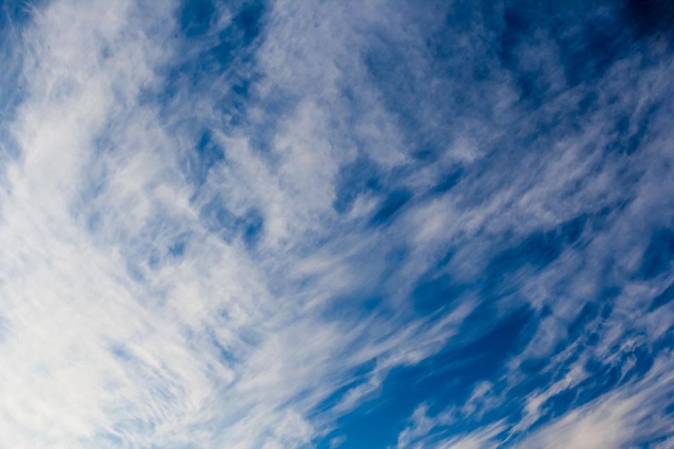 Free Image of Plane Flying Through Cloudy Blue Sky 