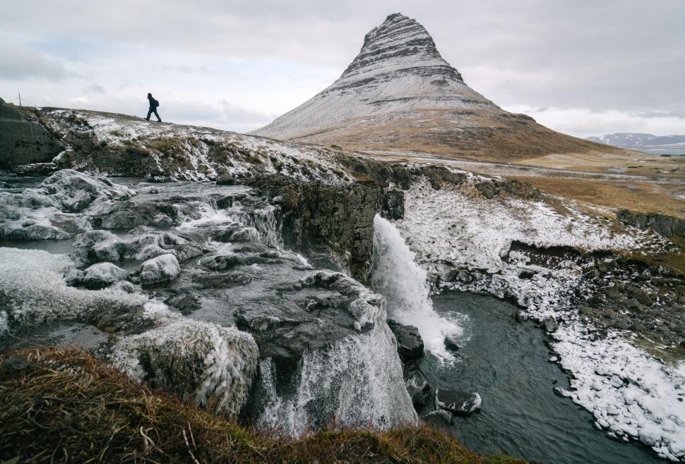 Free Image of Man Standing on Top of Snow-Covered Mountain 