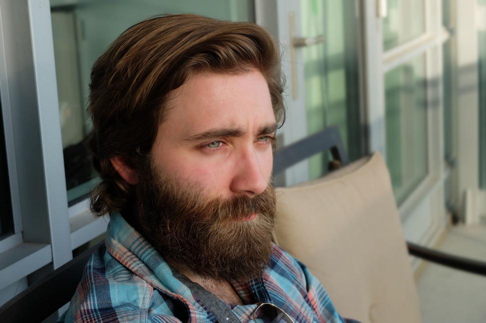 Free Image of A Man With a Beard Sitting on a Couch 