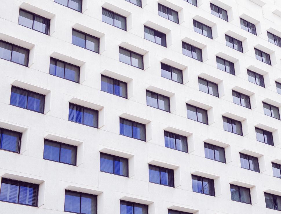 Free Image of Tall White Building With Lots of Windows 