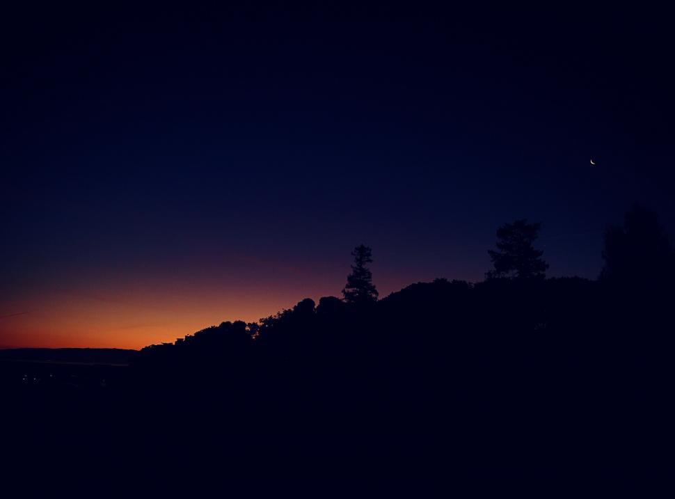 Free Image of Sun Setting Over Hill With Trees 