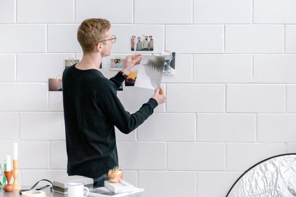 Free Image of Man Standing in Front of White Brick Wall 