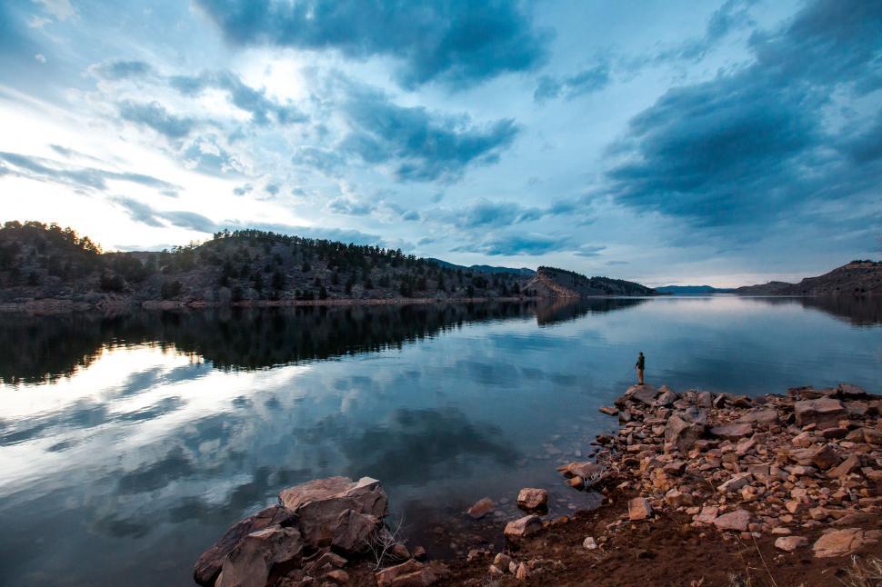 Free Image of Man Standing on Shore of Lake 