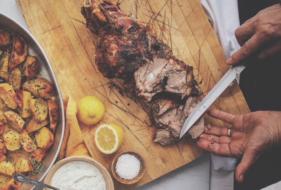 Free Image of Person Holding Knife Next to Plate of Food 