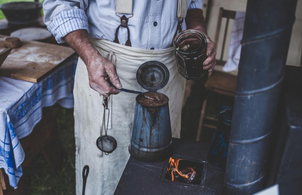 Free Image of Man Holding Coffee Pot With Apron 