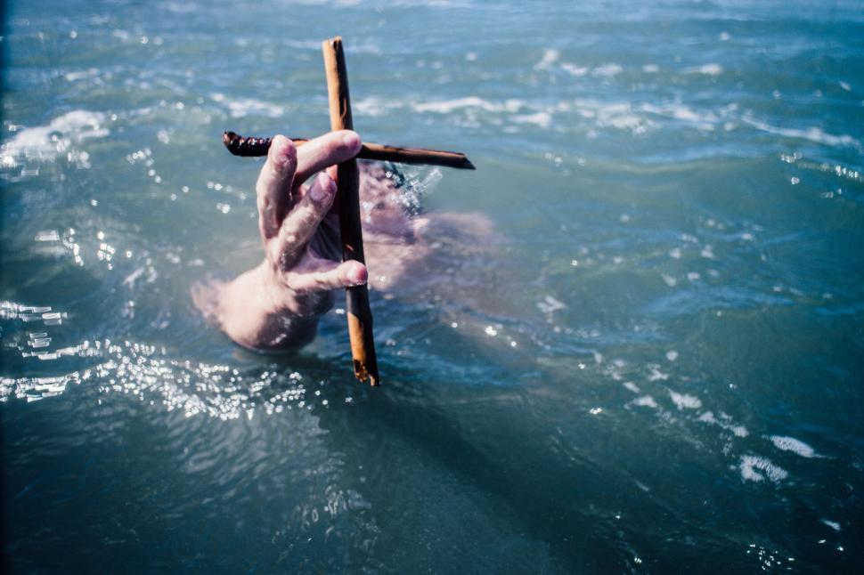 Free Image of Man Floating in Water With Stick 