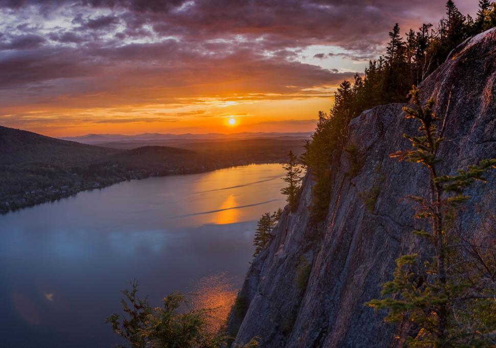 Free Image of The Sun Setting Over a Lake in the Mountains 