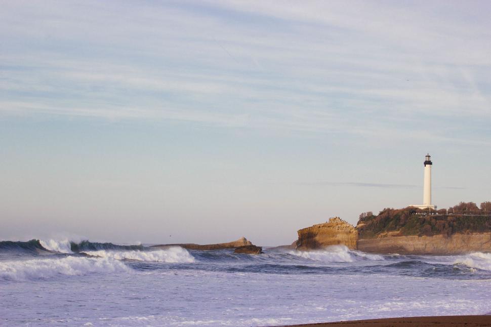 Free Image of Lighthouse on Rocky Outcropping by Ocean 