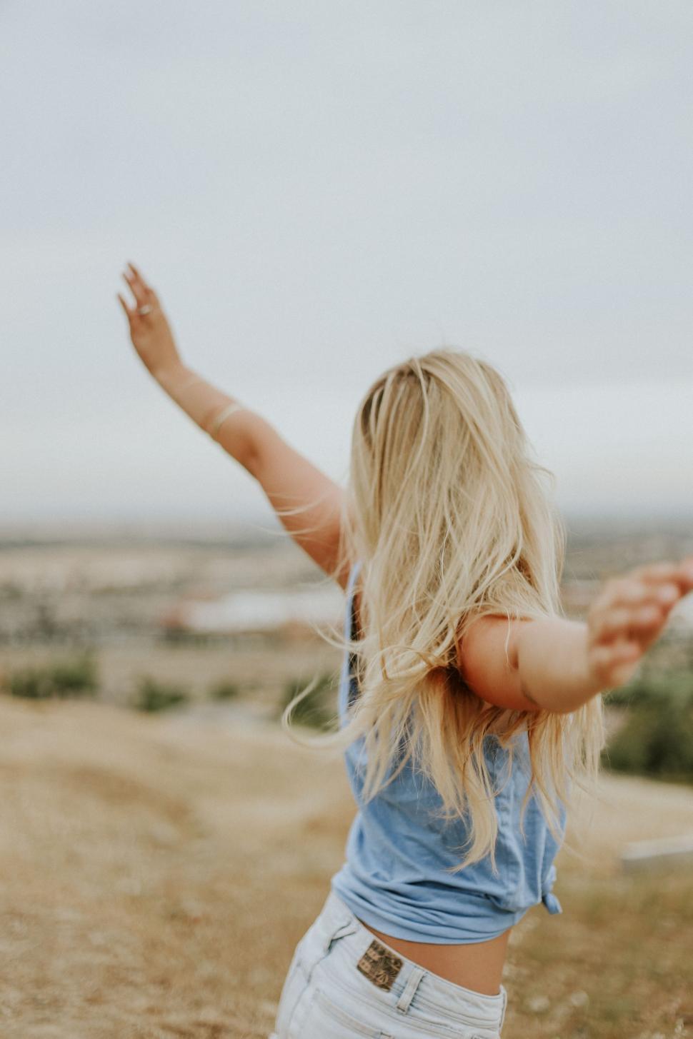 Free Image of Woman in Blue Shirt Flying a Kite 