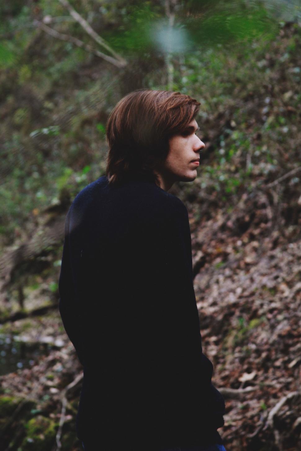 Free Image of Man Standing in Woods Holding Frisbee 