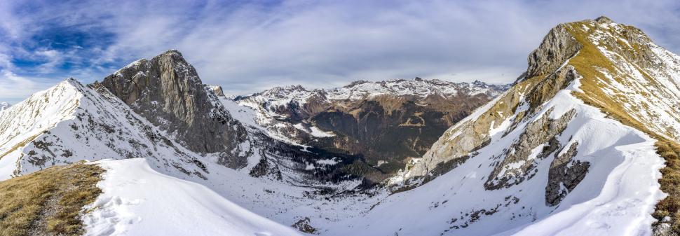 Free Image of Snow Covered Mountain Range Under Cloudy Blue Sky 
