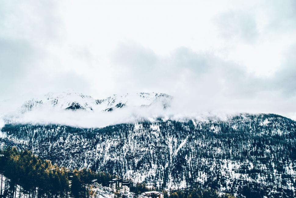 Free Image of Snowy Mountain With Clouds in the Distance 