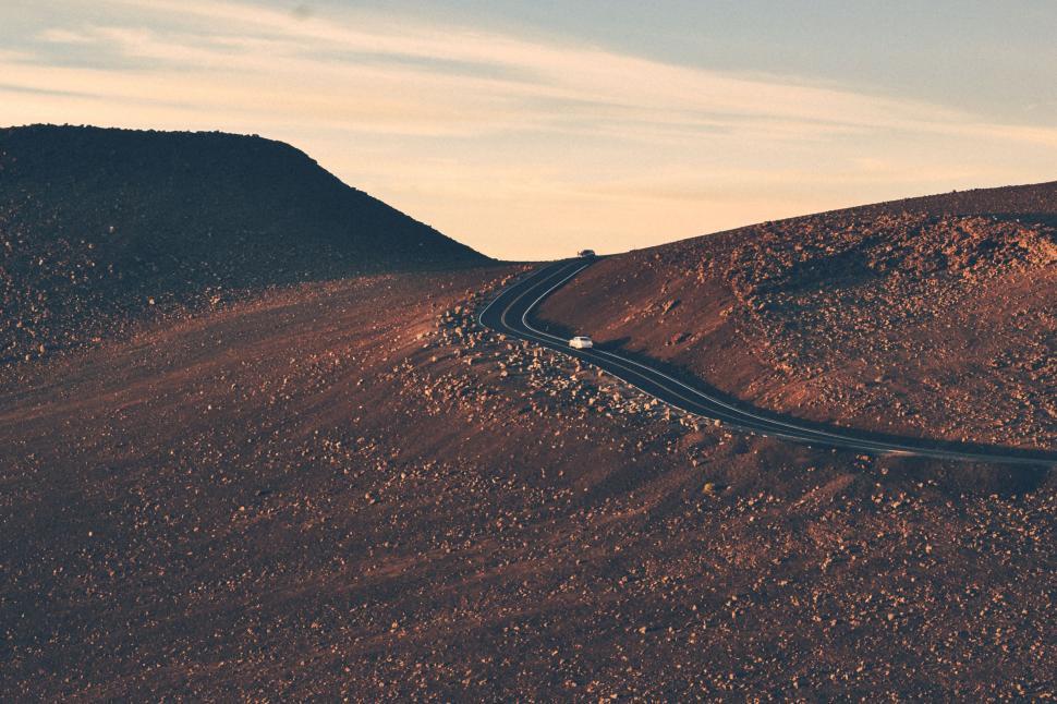 Free Image of Car Driving Down Winding Desert Road 