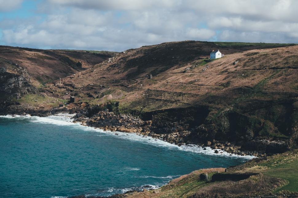 Free Image of House Perched on Hill Above Water 