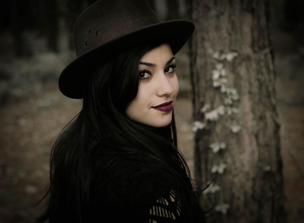 Free Image of Woman Wearing Hat Standing Next to Tree 