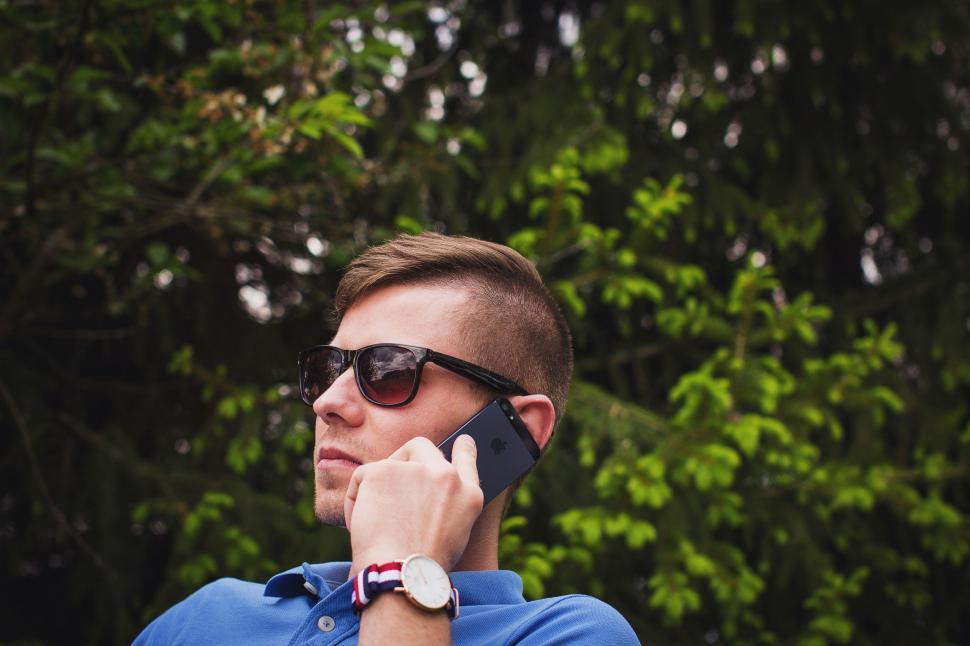 Free Image of Man Wearing Sunglasses Talking on Cell Phone 