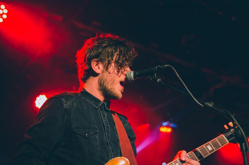 Free Image of Man Playing Guitar in Front of Microphone 