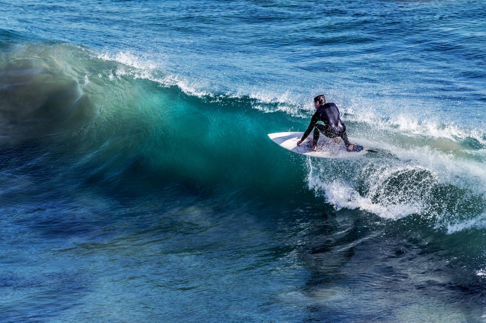 Free Image of Man Riding Wave on Surfboard 