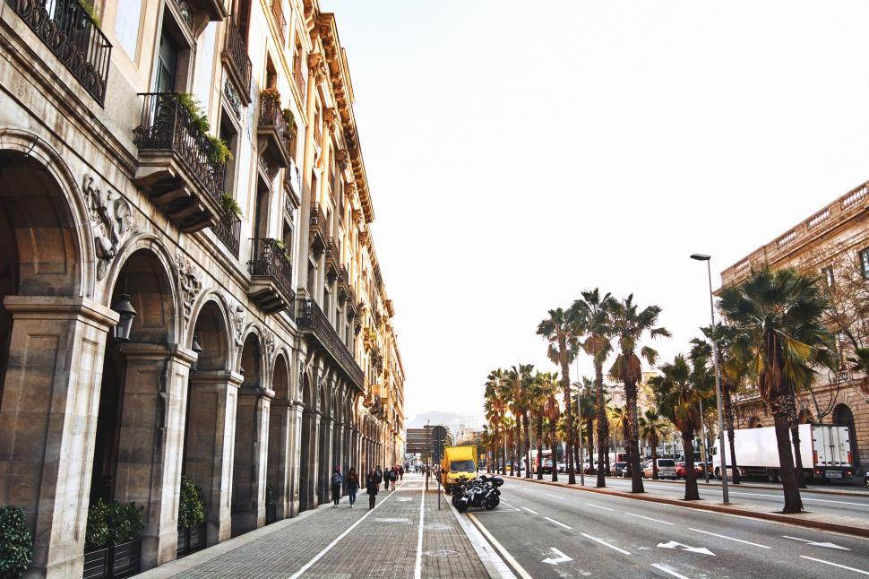 Free Image of Car Driving Down Street Next to Tall Buildings 