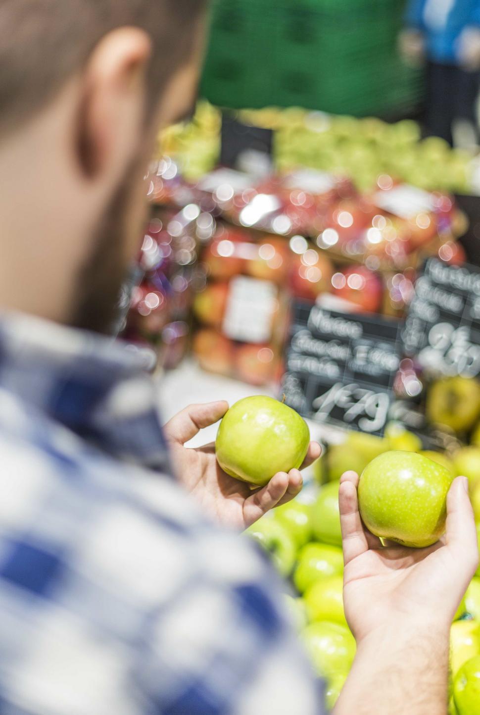 Free Image of Man Holding Two Green Apples 
