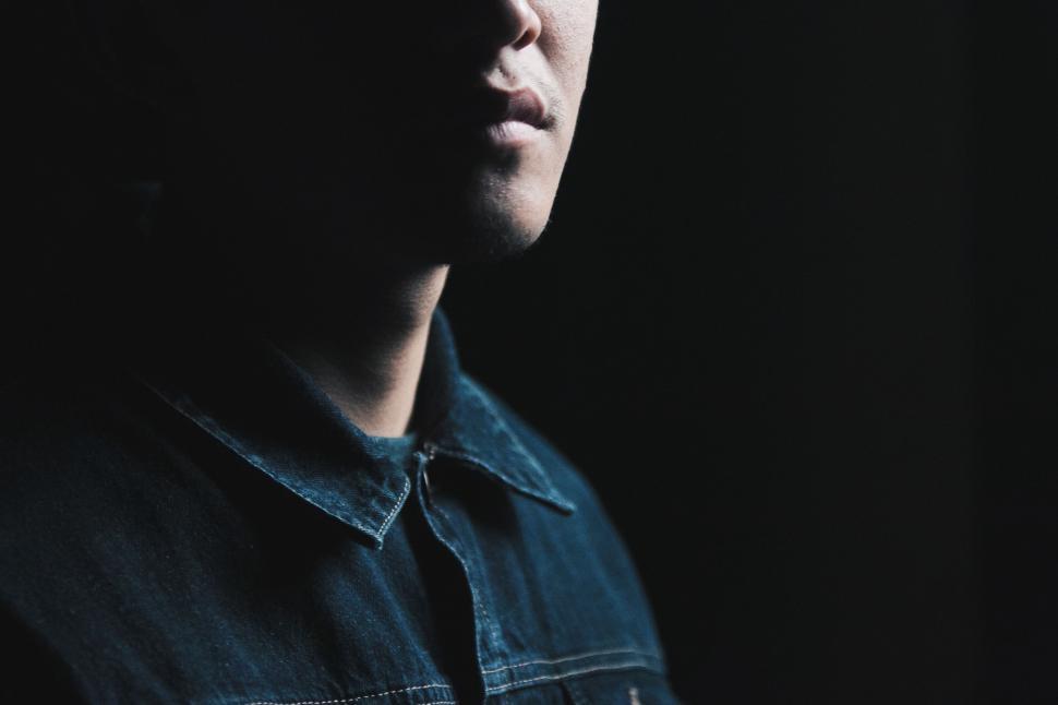 Free Image of Man Sitting in Dark Room With Eyes Closed 