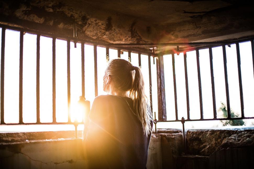 Free Image of Woman Standing in Front of a Jail Cell 
