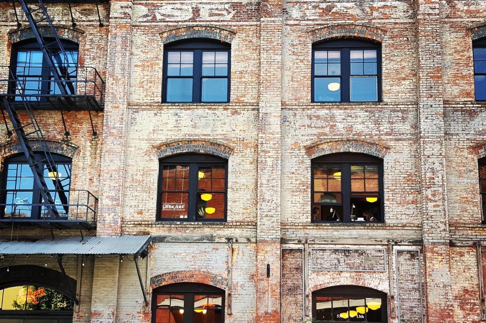 Free Image of Old Brick Building With Many Windows and Fire Escape 