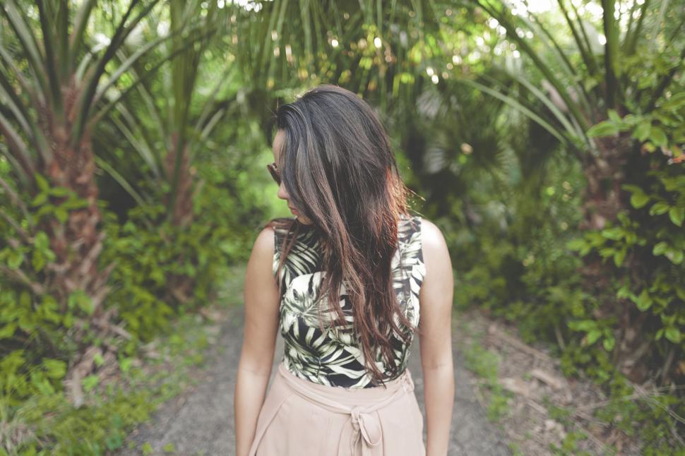 Free Image of Woman Walking Along Dirt Road by Forest 