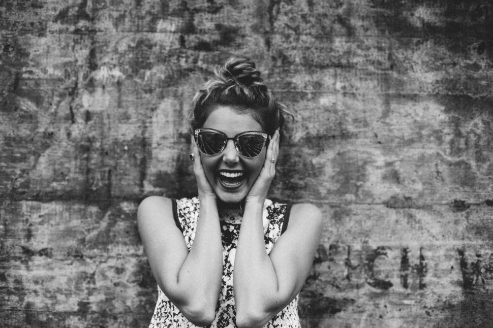 Free Image of Woman Wearing Sunglasses Holding Hands to Face 