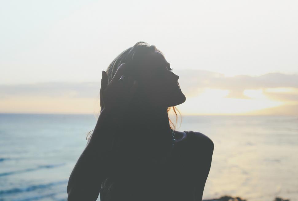 Free Image of Woman Standing in Front of Body of Water 