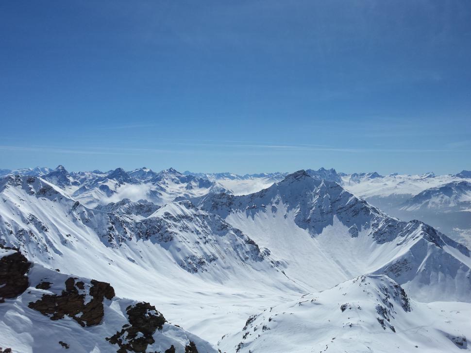 Free Image of Snowboarder Standing on Top of Snowy Mountain 