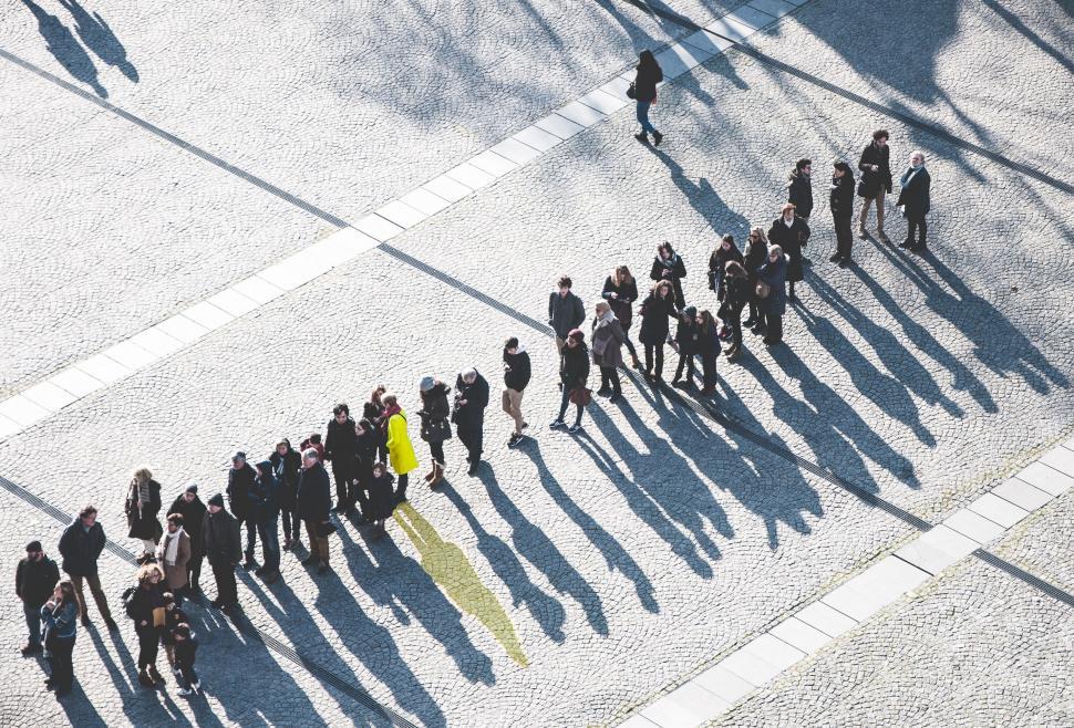 Free Image of Group of People Standing in Line on Sidewalk 