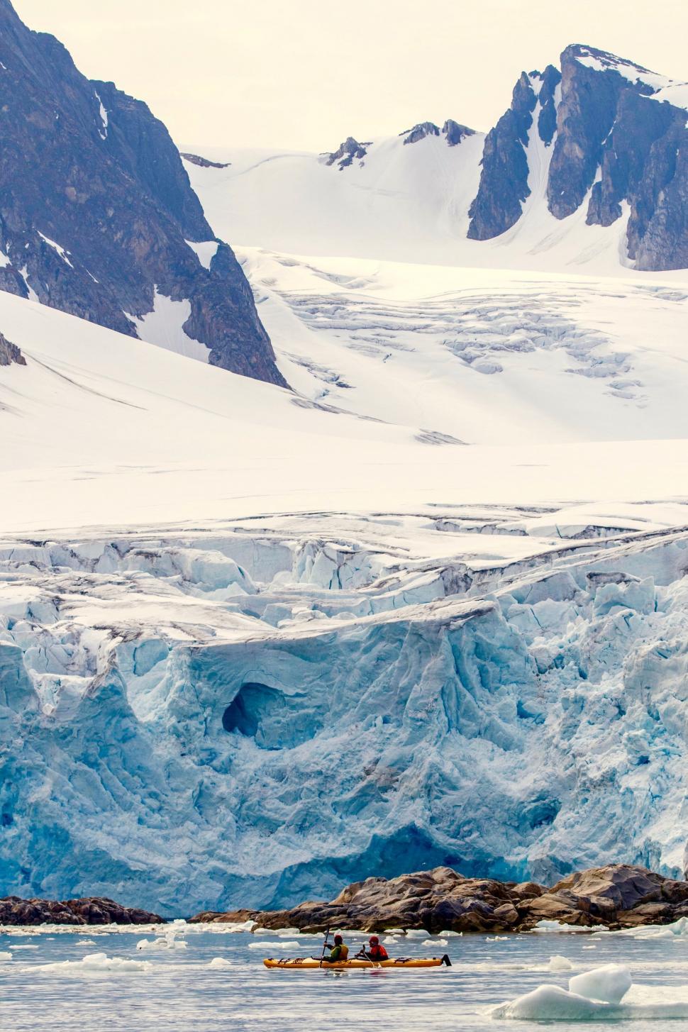 Free Image of Group of People Kayaking in Front of Glacier 