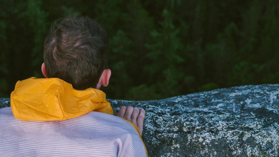 Free Image of Man in Yellow Jacket Observing a Rock 