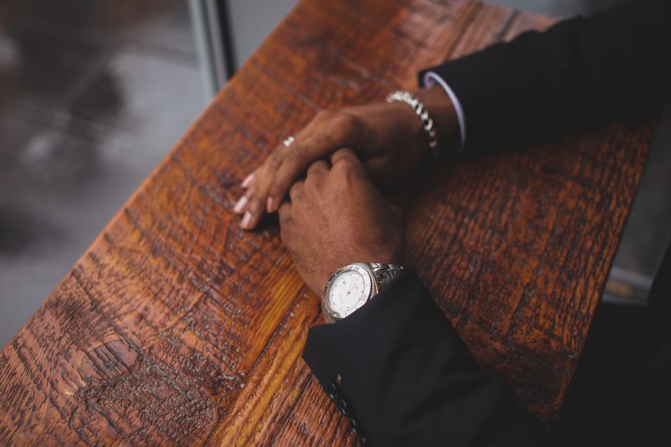 Free Image of Person Sitting at Table With Watch on Wrist 