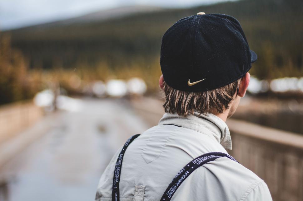 Free Image of Man With Hat and Backpack Looking at Road 
