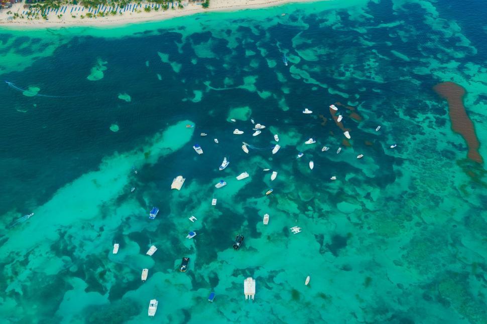 Free Image of Group of Boats Floating in Ocean Next to Beach 
