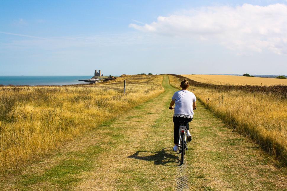 Free Image of Man Riding Bike Down Dirt Road 