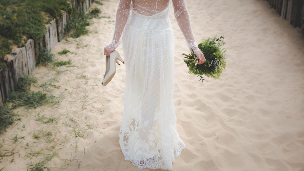 Free Image of Woman in White Dress Walking Down Path 