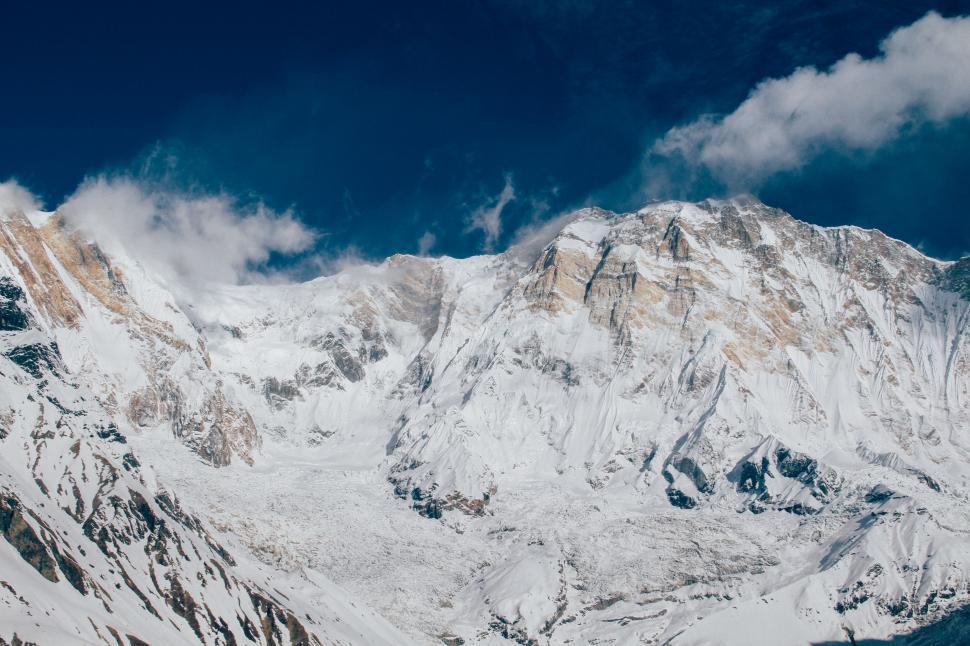 Free Image of Snow-Covered Mountain Under Cloudy Blue Sky 